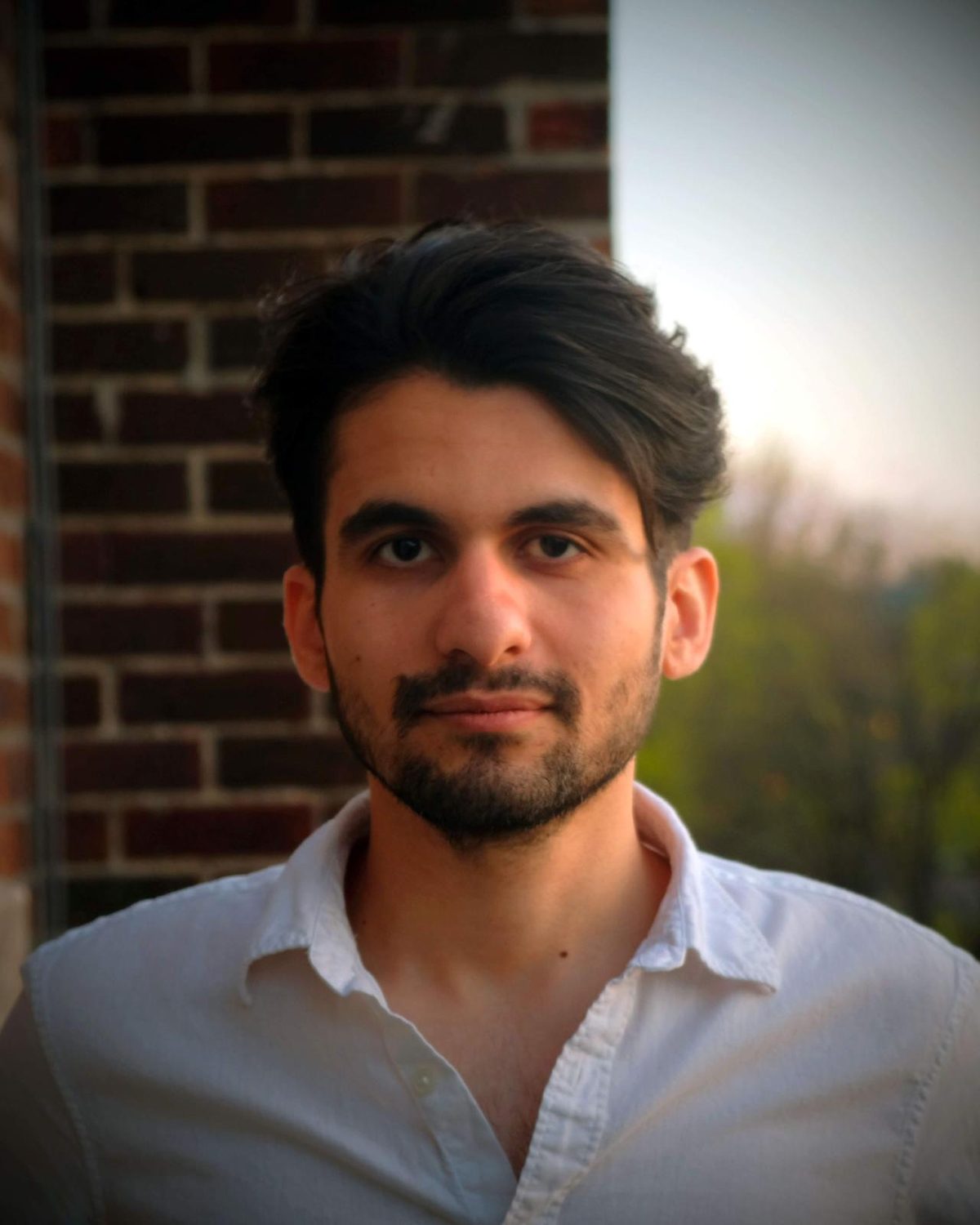 Payraw at golden hour, in front of a brick wall.